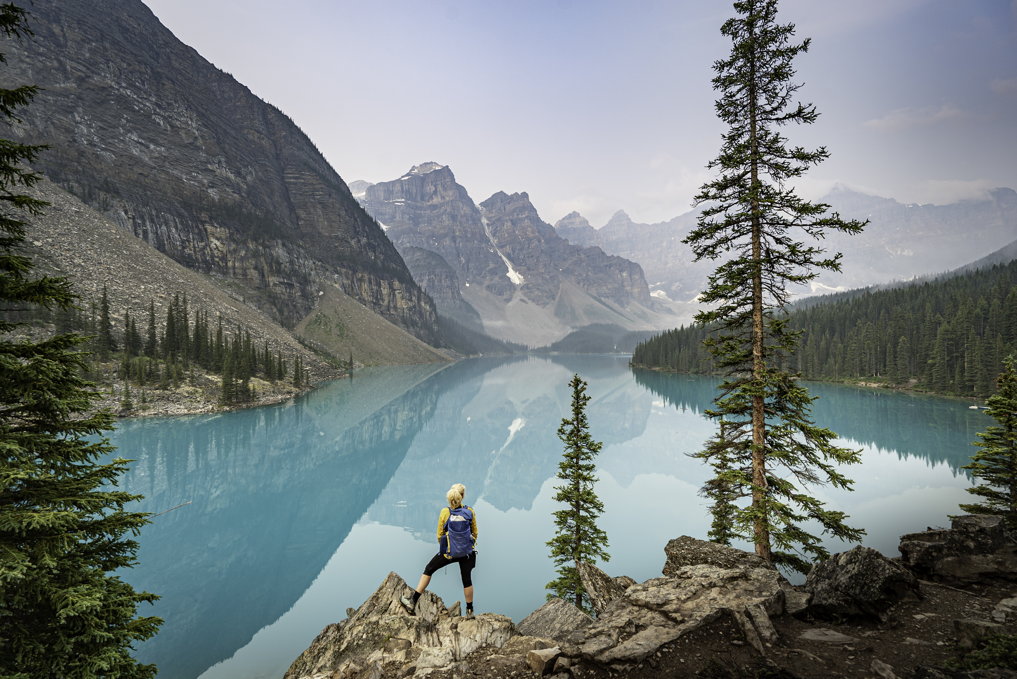 A serene turquoise lake surrounded by pine forests and mountains in the Canadian Rockies